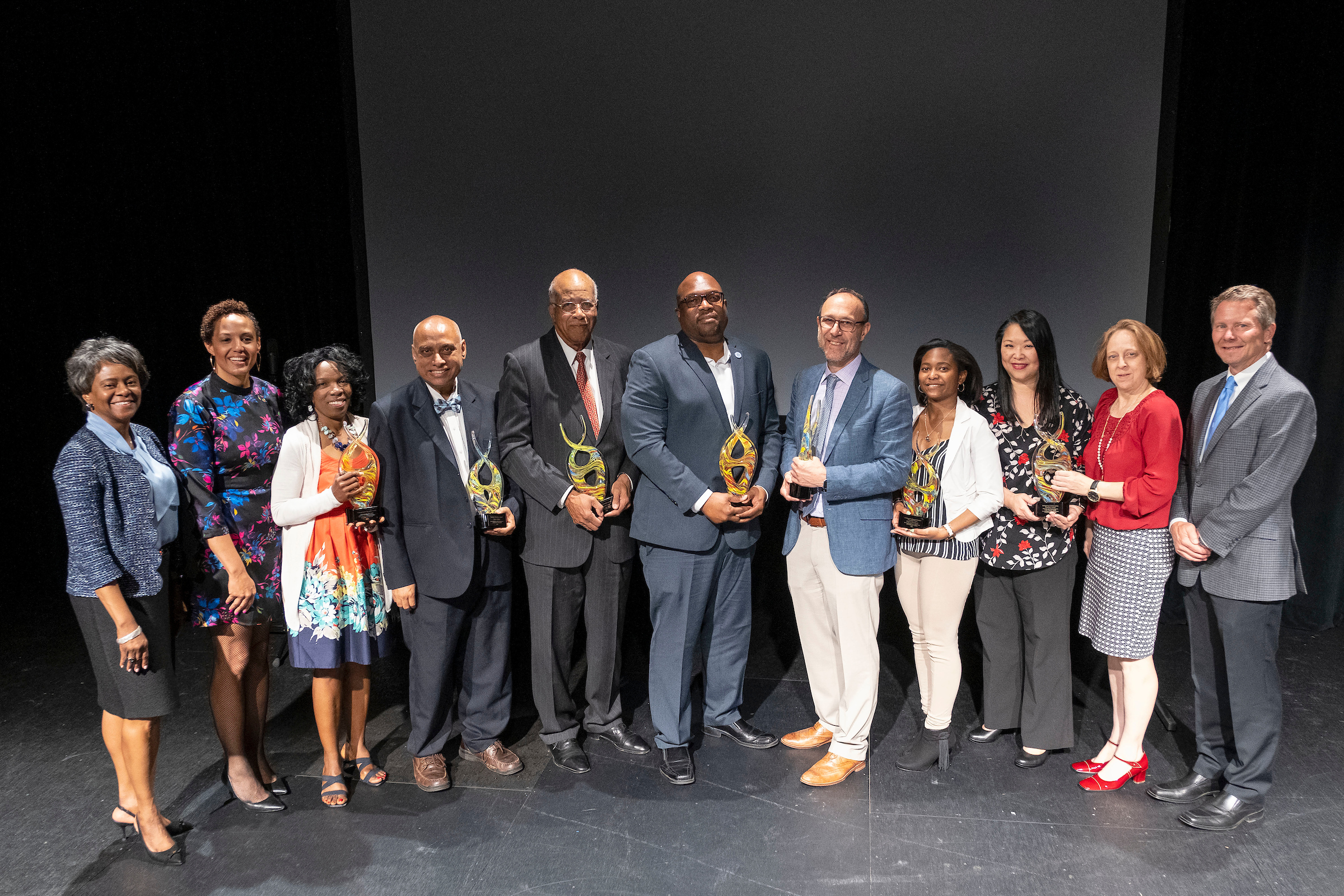 Winners of the 2019 Diversity Awards pose with their awards on stage during the ceremony.