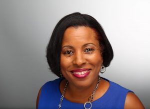 Portrait of Dr. Trevy McDonald. Dr. McDonald is a Black woman with short straight bob. She is wearing a blue blouse and hoop earrings and smiling at the camera.